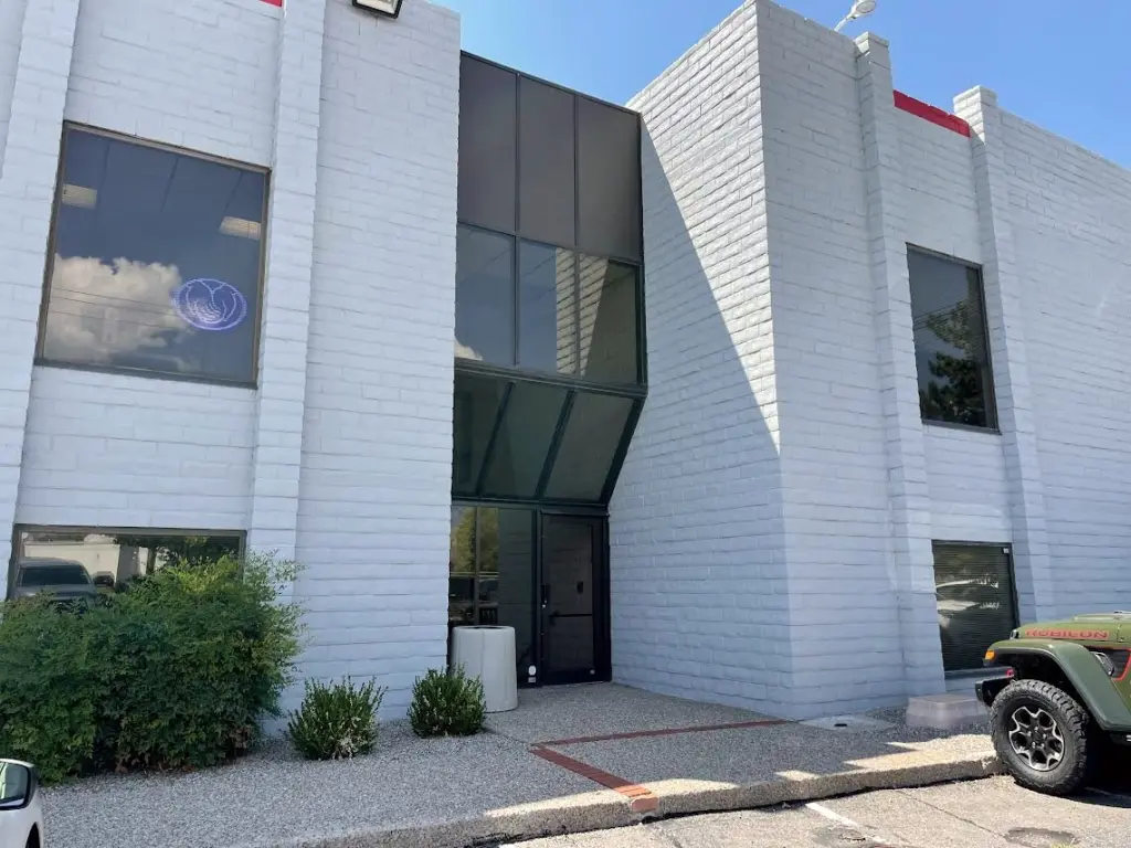 The white brick office building at 5345 Wyoming Blvd NE, Albuquerque, with its glass entrance