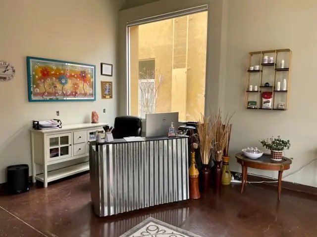 The Bernalillo front desk with its corrugated-metal front, a bright flower painting and gold shelves