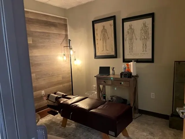 An adjusting room in the Bernalillo office: a drop table against a wood-plank wall under anatomy charts