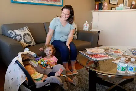 A mother with her toddler and baby relaxing on the sofa in the waiting area